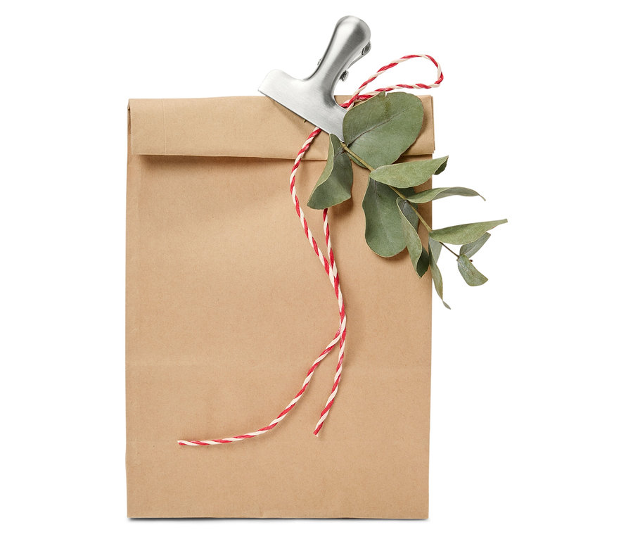 Hnědá papírová taška s klipem, provázkem a eukalyptem.