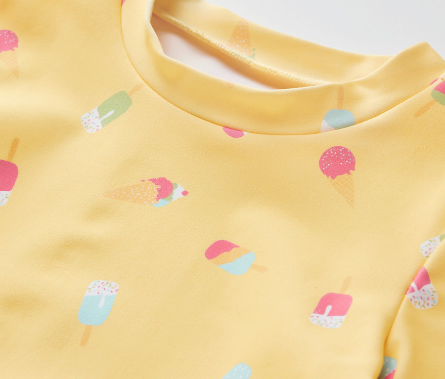 Detail žluté dětské soupravy s UV filtrem 80 a potiskem zmrzliny.