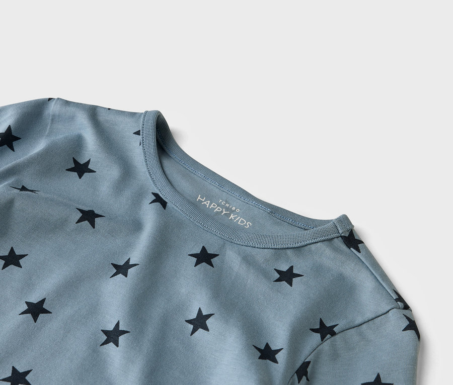 Detailní záběr na světle modré tričko HAPPY KIDS s černými hvězdami.