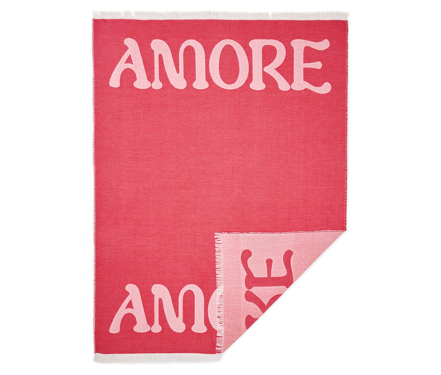 Červená deka s nápisem "AMORE" růžovým písmem.