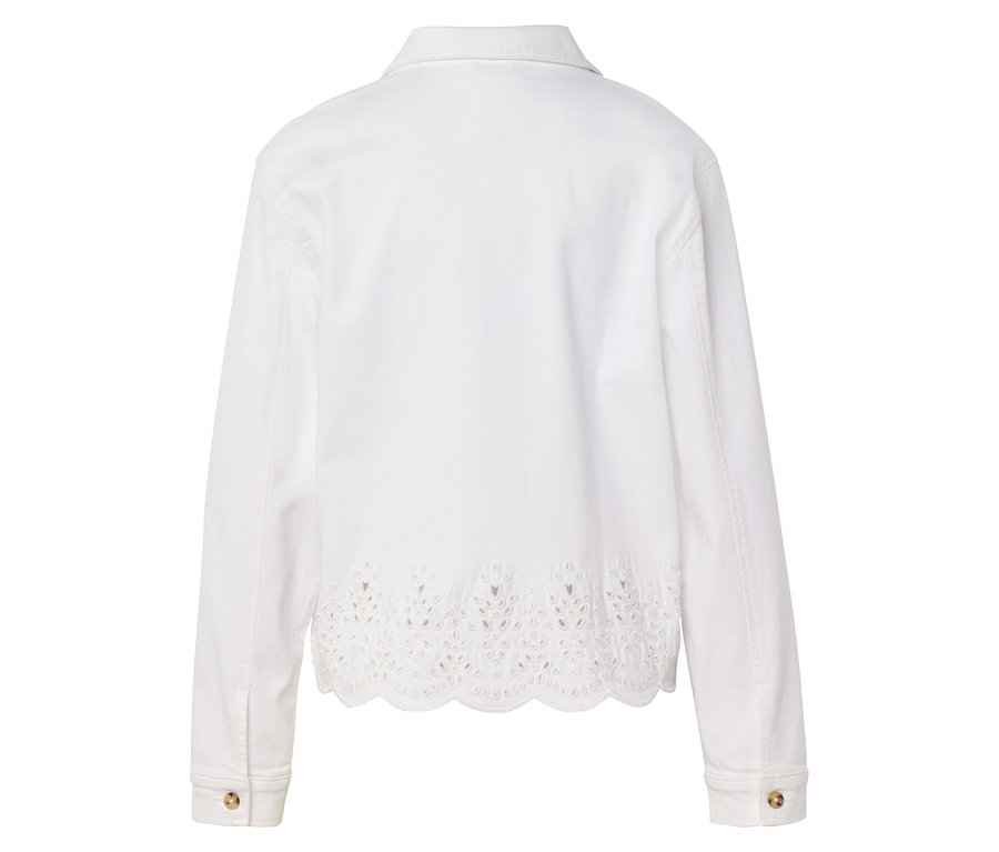 Pohled zezadu na bílou bundu s děrovanou výšivkou na lemu.