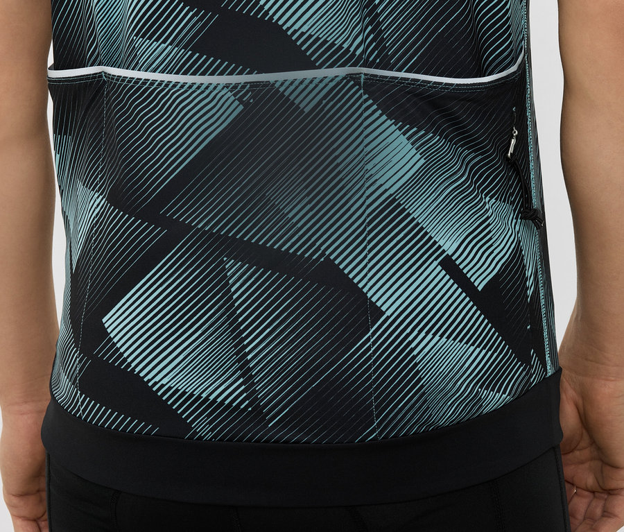 Detailní záběr na zadní část cyklistického dresu s geometrickým vzorem v černé a tyrkysové barvě.