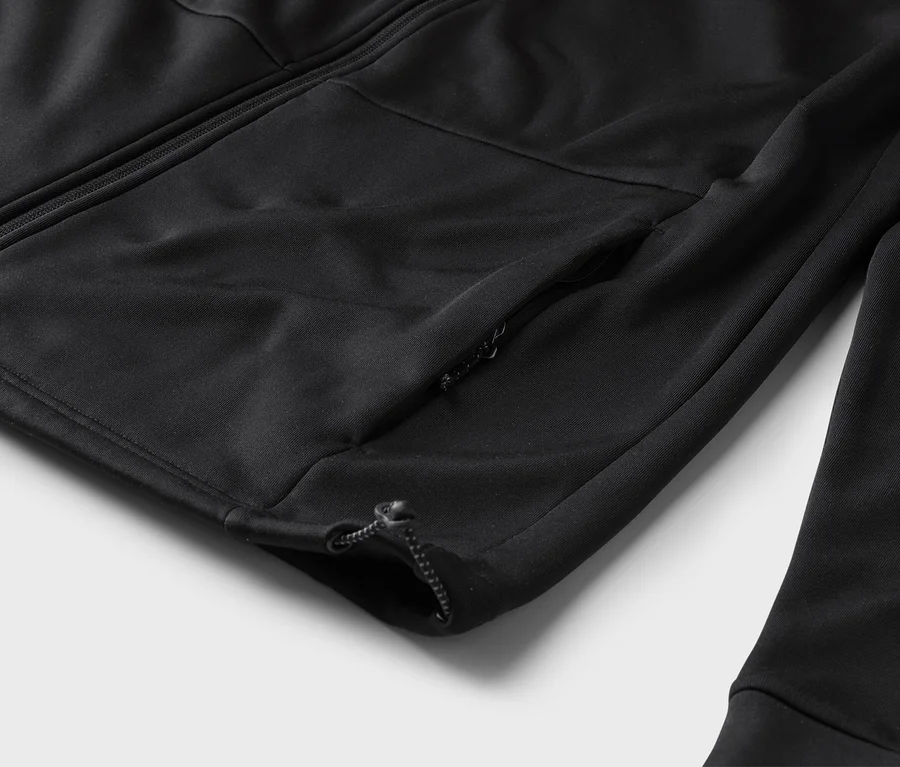 Detail černého tréninkového svetru se zipem a kapsou na zip na rukávu.
