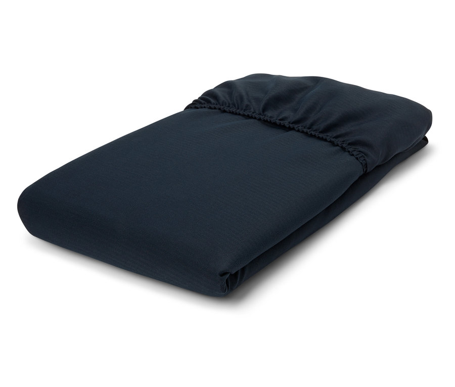 Složená tmavě modrá prostěradla s gumičkou na bílém pozadí.
