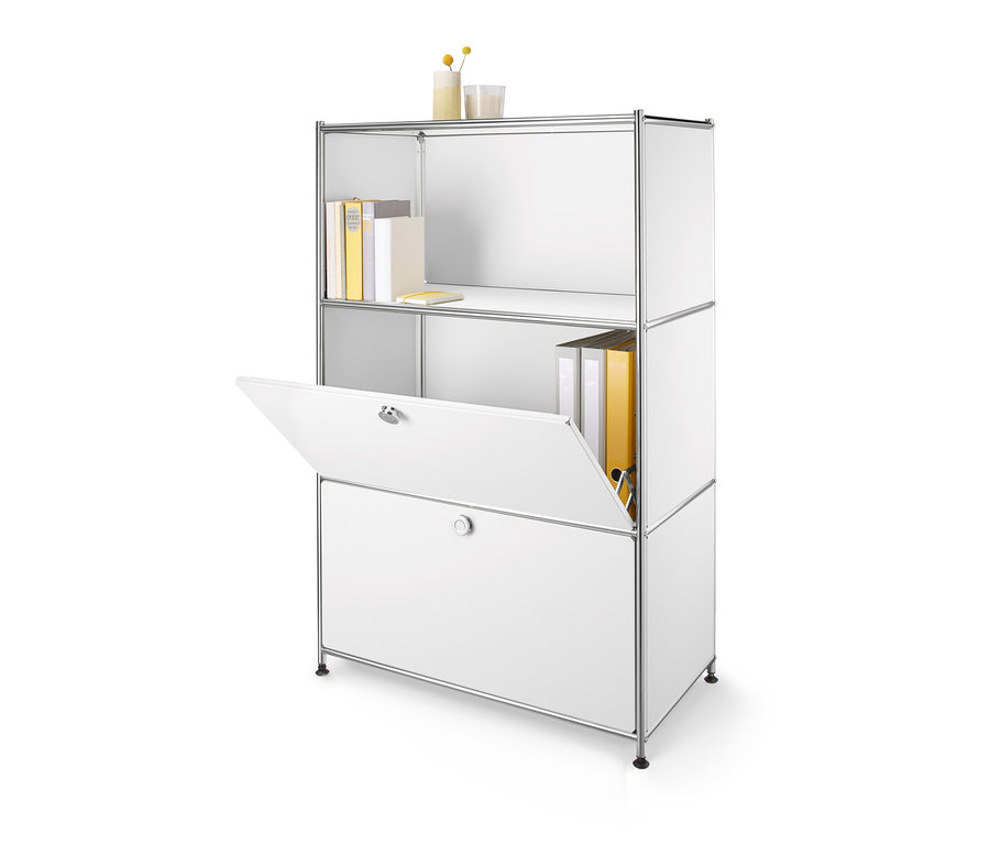 Bílý kovový regál se 2 přemístitelnými výklopnými dvířky, jedny dvířka jsou otevřené.