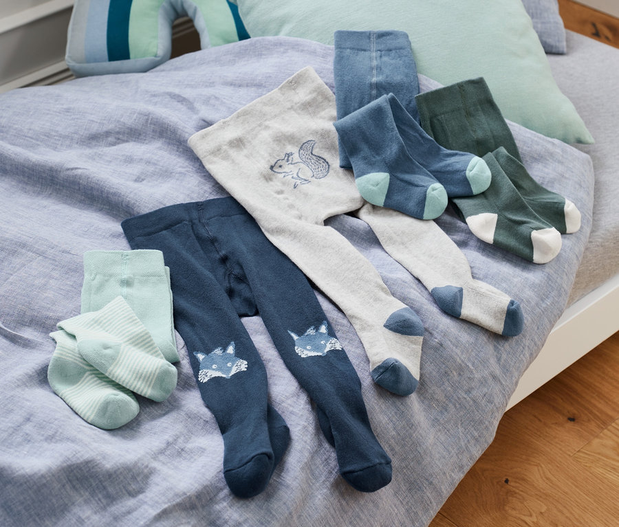 Na posteli leží modré bavlněné punčocháče (5 ks) a ponožky.