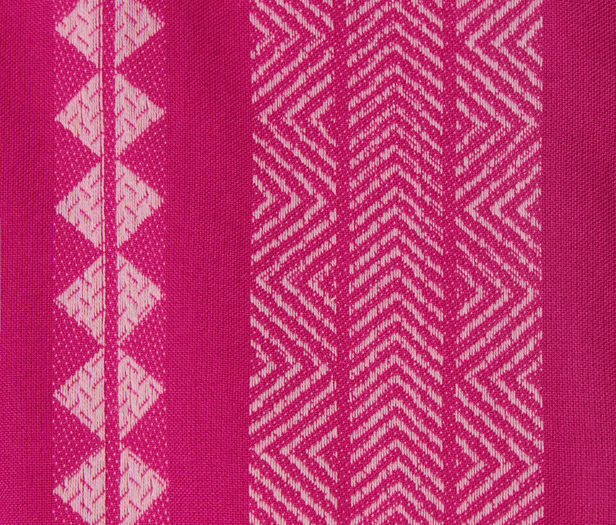 Detail tkané růžové látky se vzorem ikat.