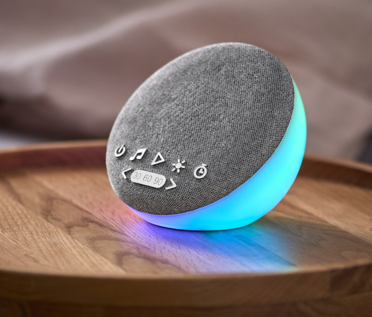 Na nočním stolku leží pomůcka pro usínání s reproduktorem a přírodními zvuky.