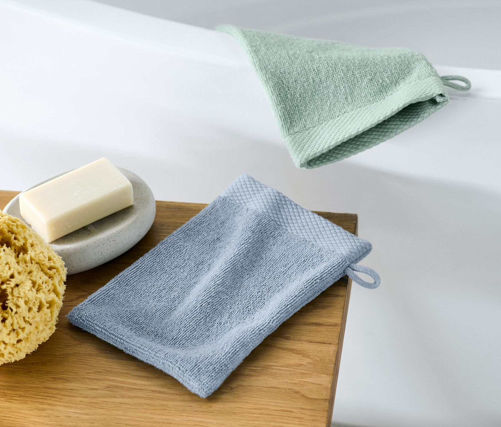 Dvě žínky leží na dřevěné stoličce vedle mýdla a houby.