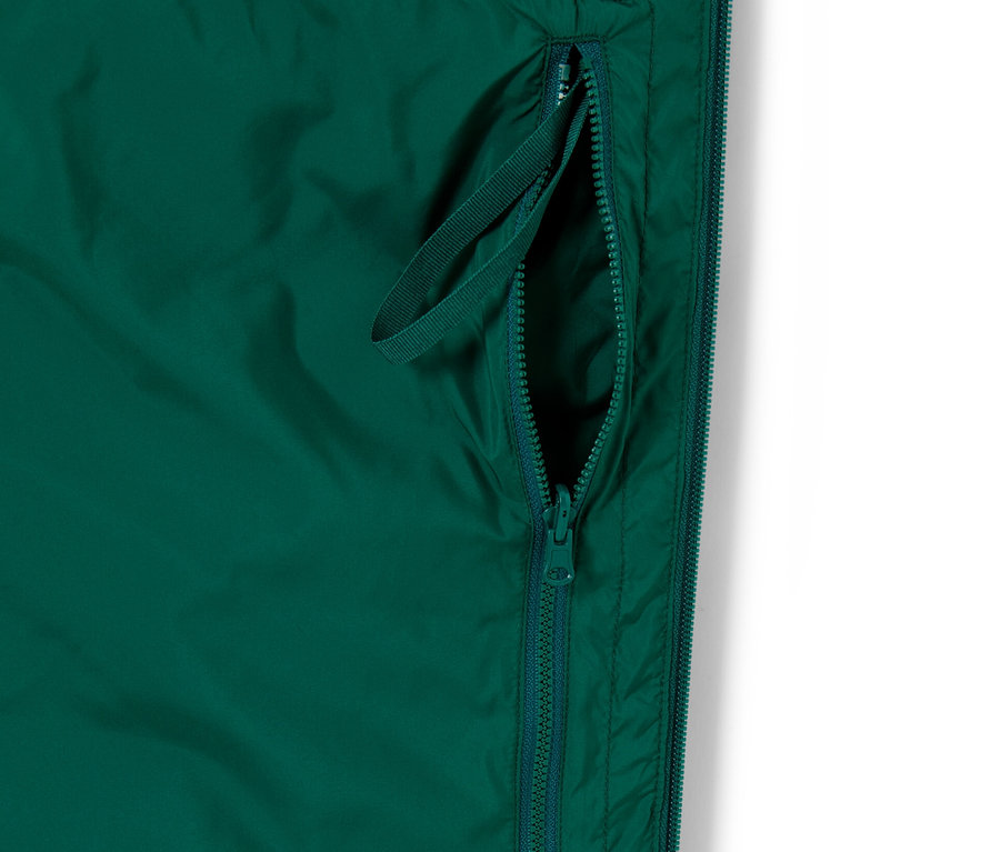 Detail zelené prošívané vesty Skladná prošívaná vesta se zipem a poutkem.