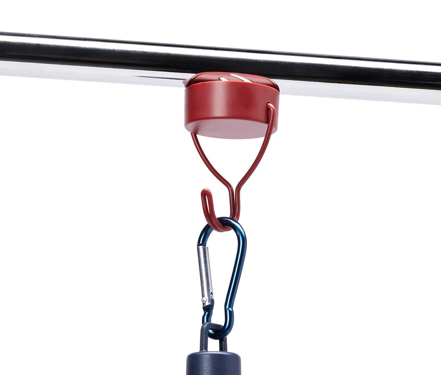 Na kovové tyči visí pomocí magnetického háčku modrá lampa.
