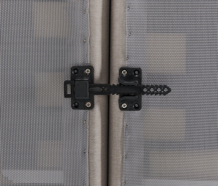 Detail černého západkového zámku na venkovní pohovce se stoličkou.