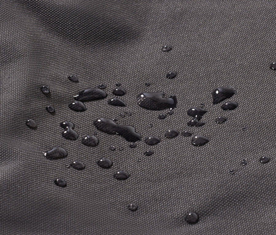 Detailní záběr na černou látku s kapkami vody.