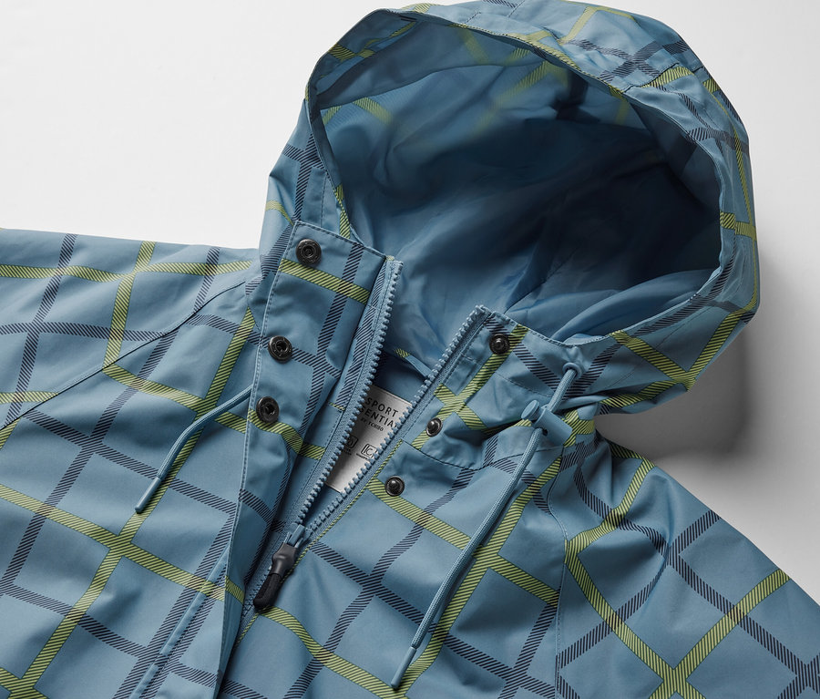 Modrá bunda do deště s kapucí a kostkovaným vzorem.