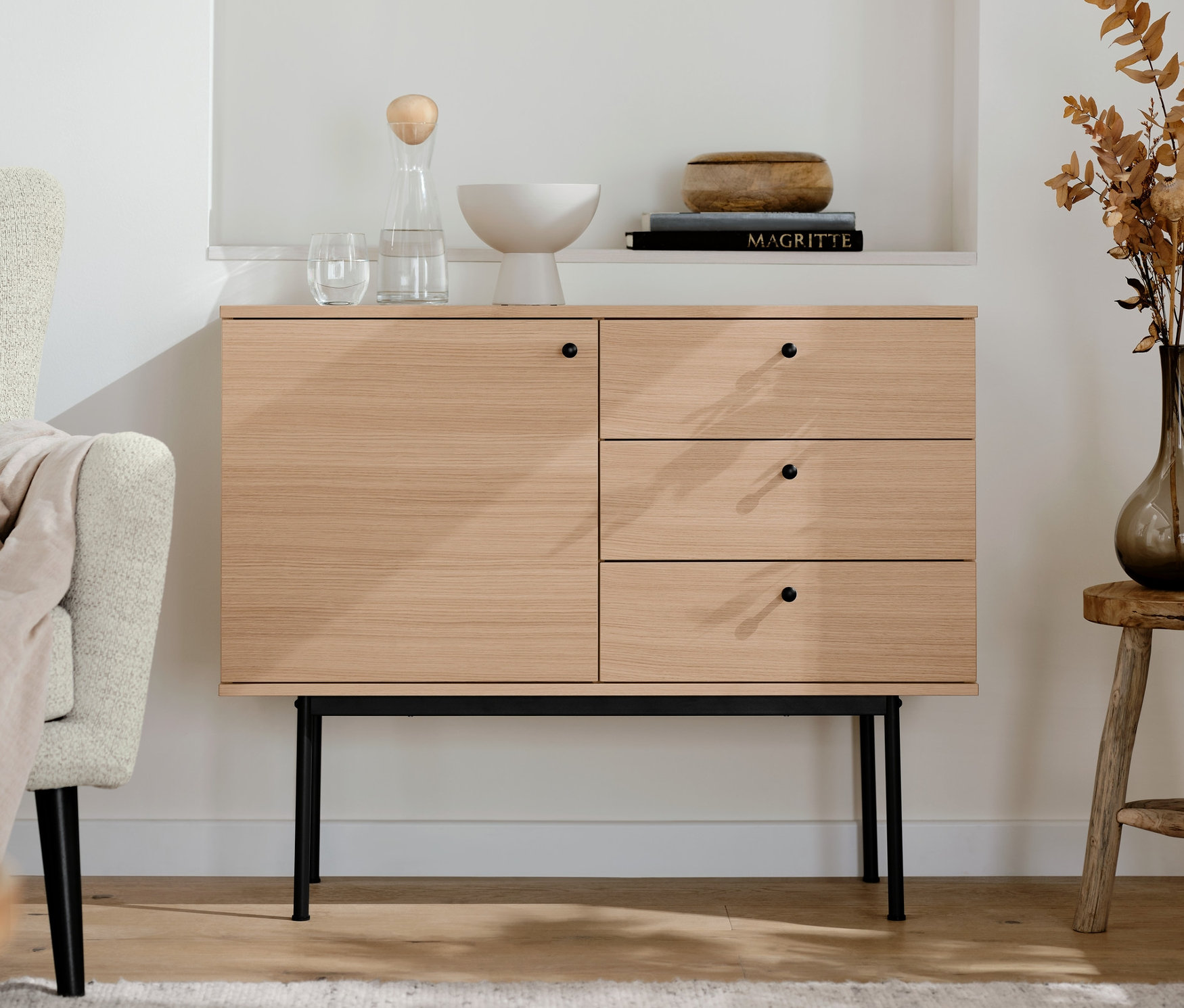 V obývacím pokoji stojí konzolový stolek »Finnsbo« se zásuvkami. Nad ním jsou police s dekoracemi.