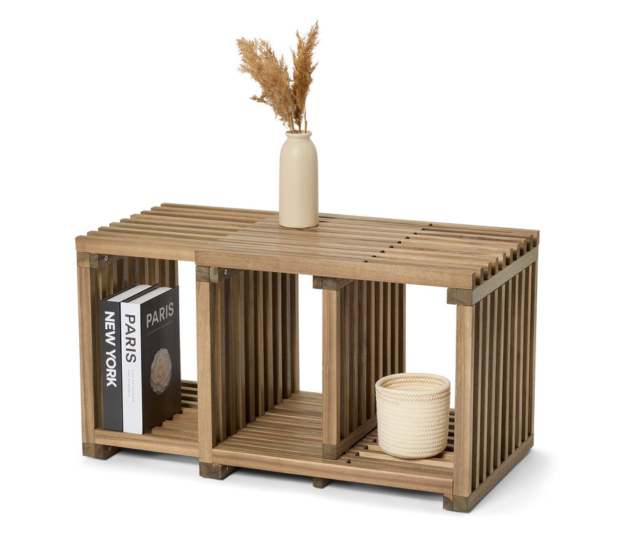 Dřevěný regál s knihami "New York" a "Paris", vázou a pleteným košíkem.