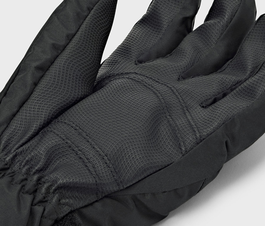 Detail černé rukavice s texturovanou dlaní.
