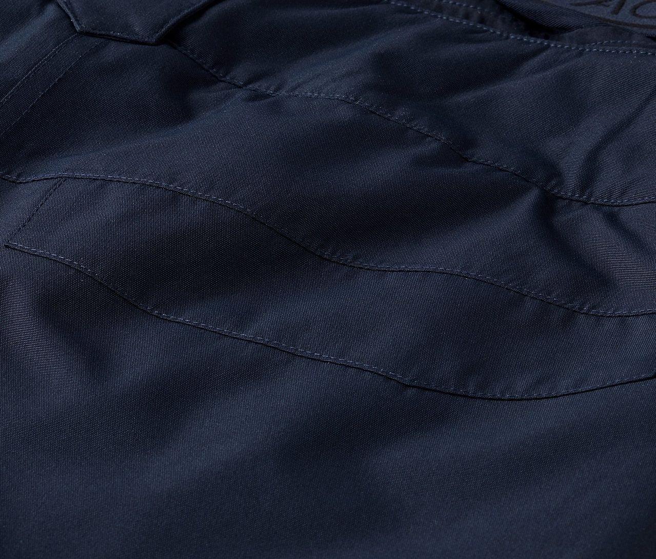 Detail záběru na námořnicky modré kalhoty s kapsou.