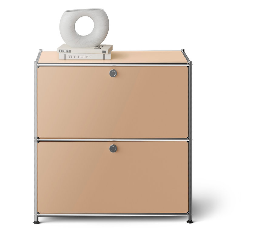 Béžová komoda se dvěma zásuvkami, na ní leží kniha a dekorativní váza.