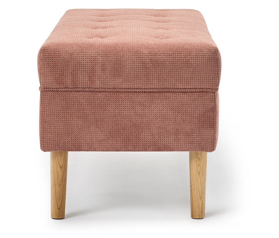 Růžová látková podnožka s dřevěnýma nohama.