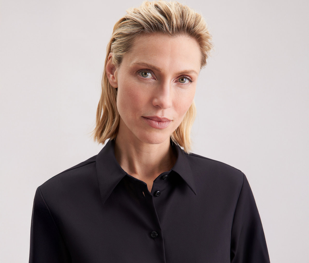 Žena má na sobě halenku regular Seidensticker.