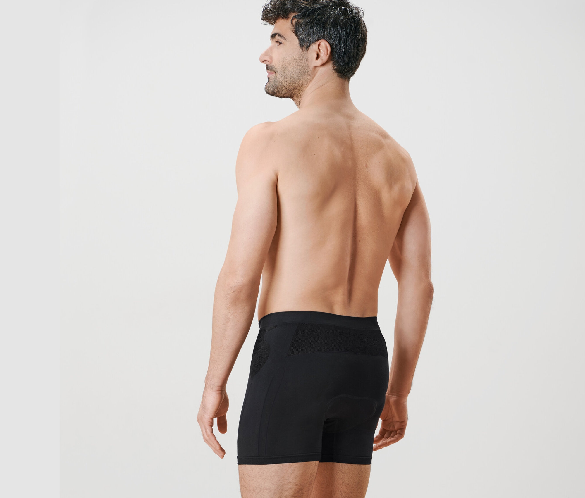 Muž zezadu má na sobě černé cyklistické šortky.