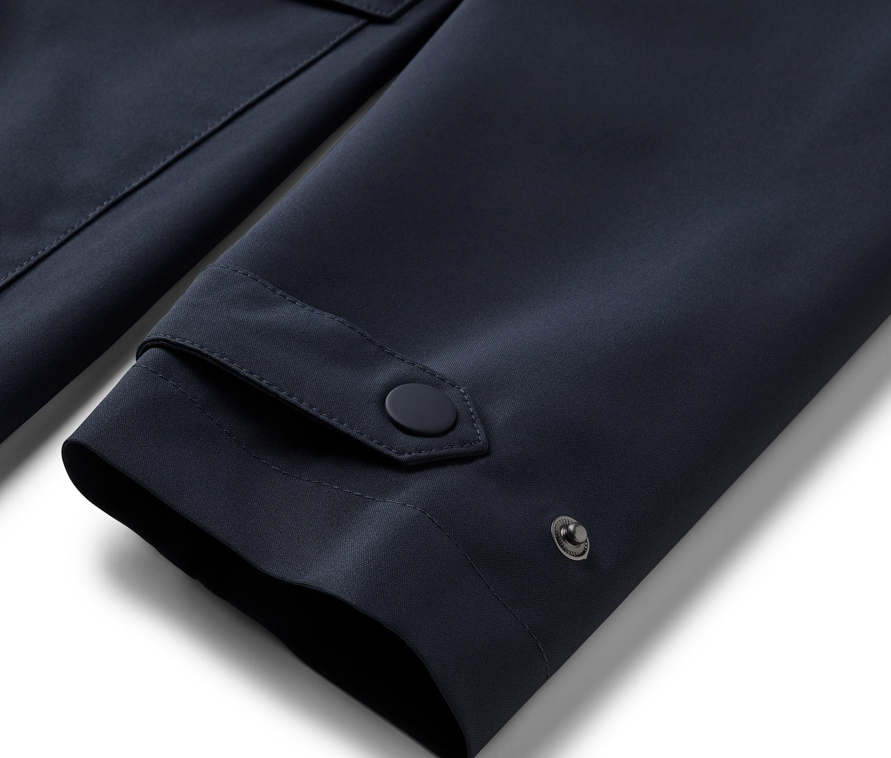 Detail rukávu modrého trenčkotu do deště.