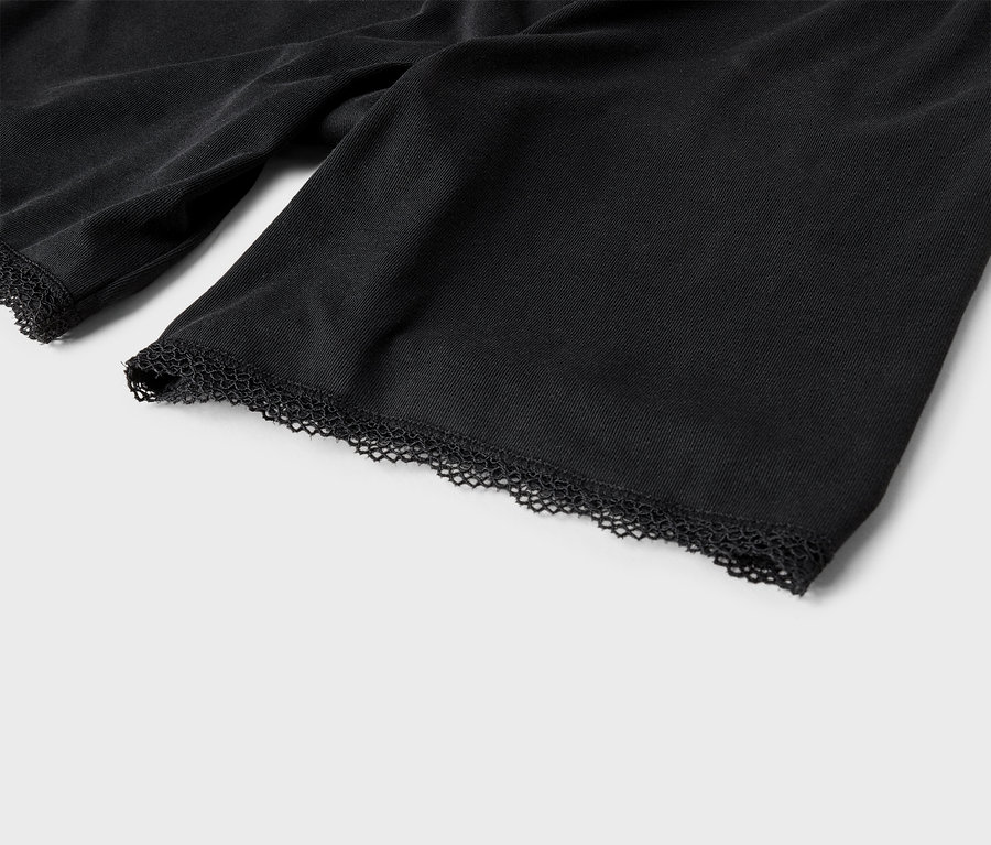 Detailní záběr rukávů černé látky s krajkovým lemem.