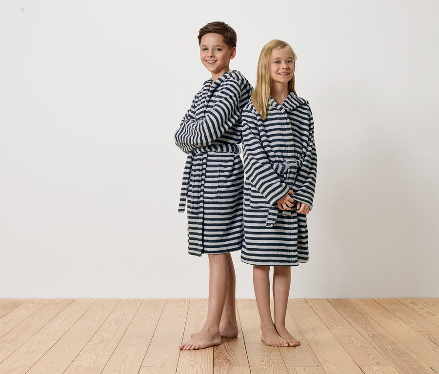 Chlapec a dívka stojí zády k sobě a mají na sobě pruhované župany.