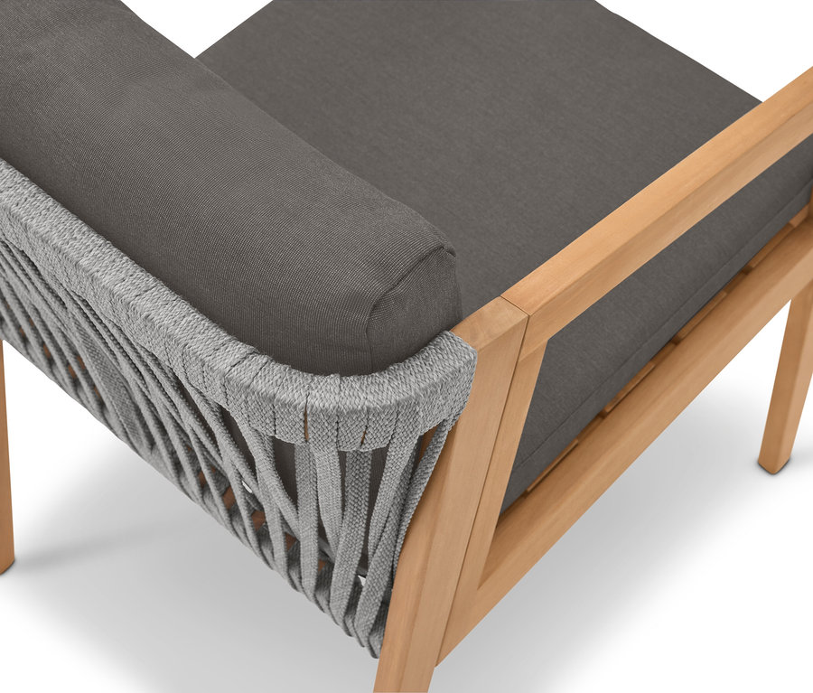 Detailní pohled na křeslo se světle hnědým dřevěným rámem, šedým čalouněním a šedým lanovým potahem.