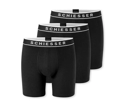 Tři černé boxerky, mírně za sebou uspořádané, s bílým pasem a logem „SCHIESSER“.