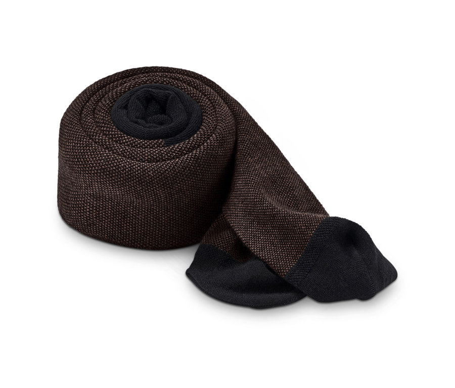 Hnědé strukturované punčochové kalhoty srolované na bílém pozadí.