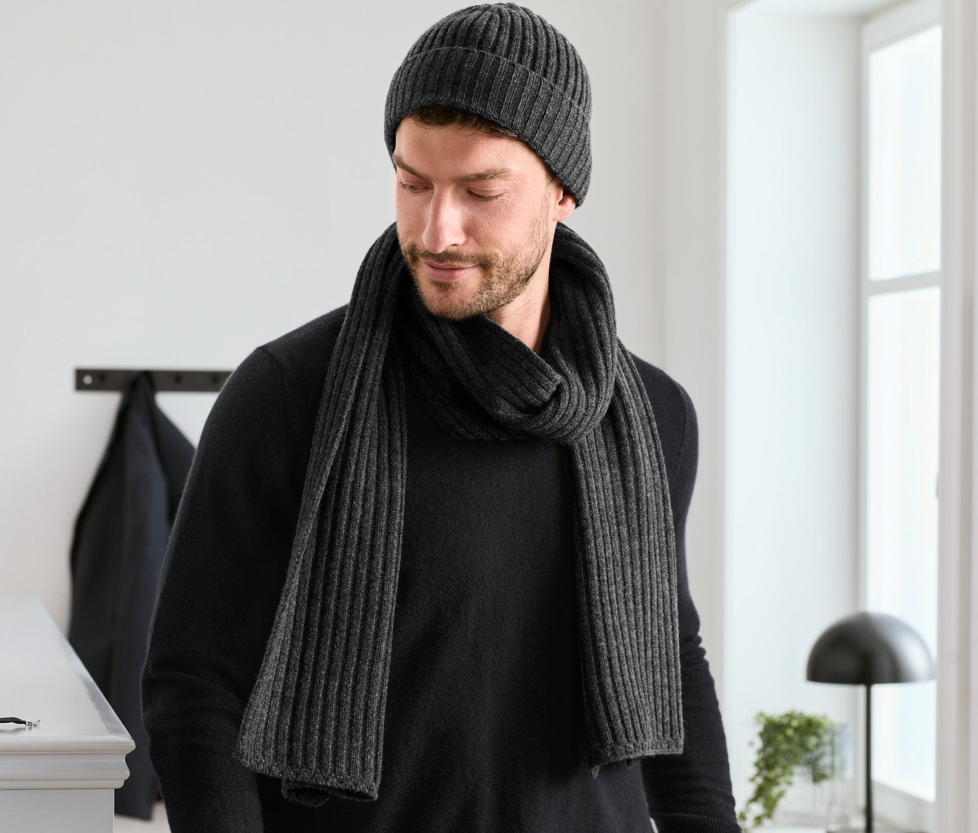 Muž má na sobě vlněnou čepici a vlněnou šálu ze soupravy.