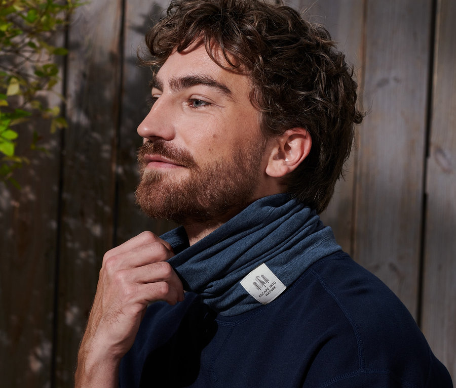 Muž si upravuje multifunkční šátek kolem krku.