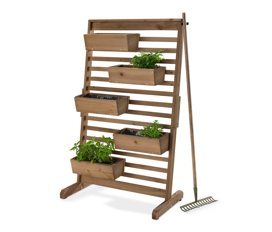 Vertikální záhon »Tinus« s flexibilně zavěsitelnými truhlíky a rostlinami, vedle stojí hrábě.