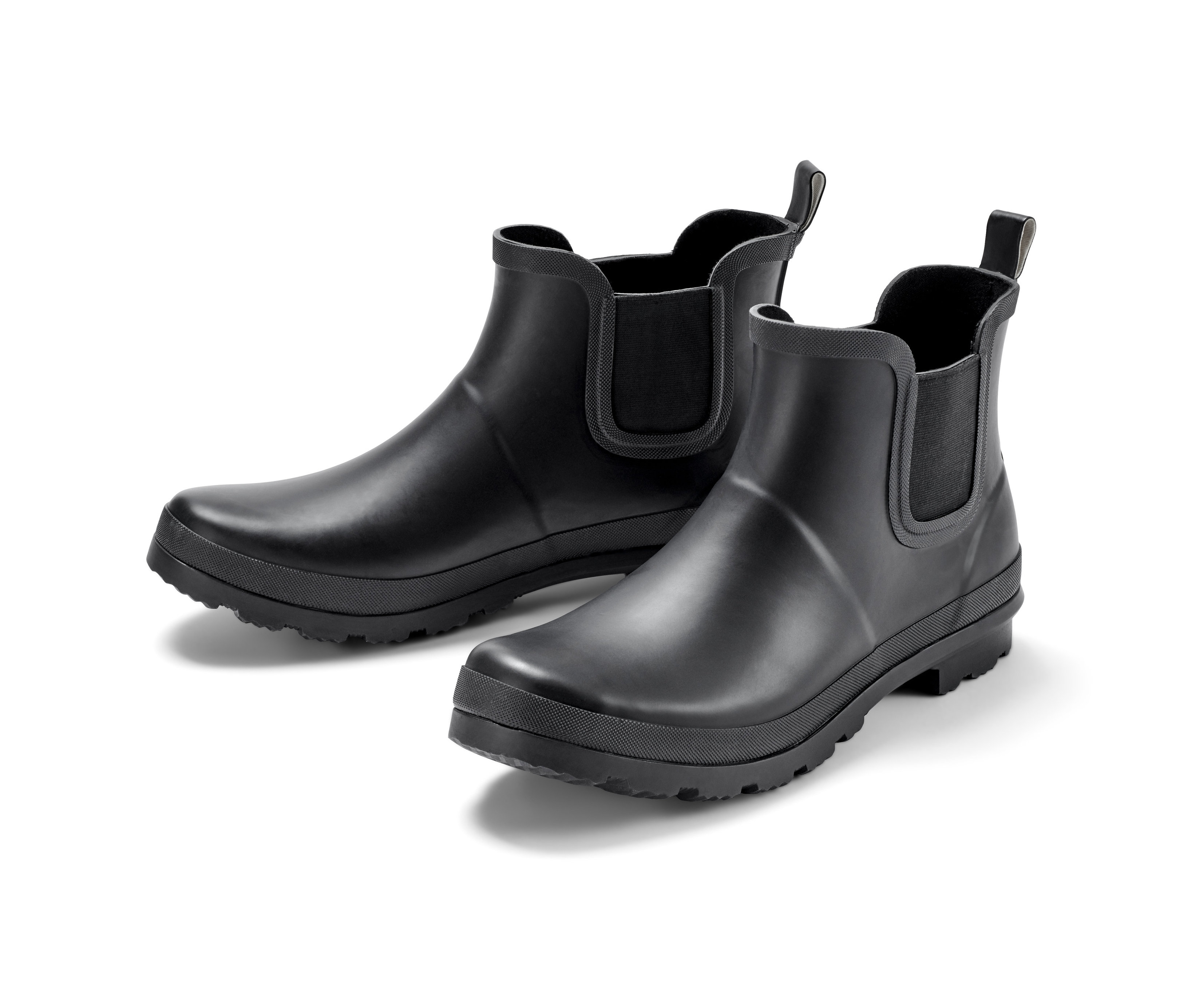 Dva páry černých bot Chelsea do deště.