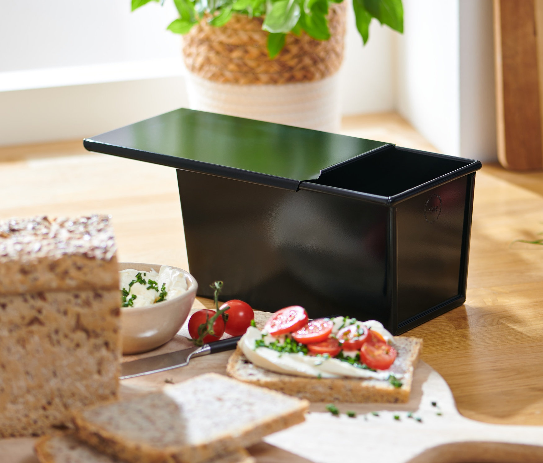 Celozrnný chléb a toastový chléb vedle formy na pečení.