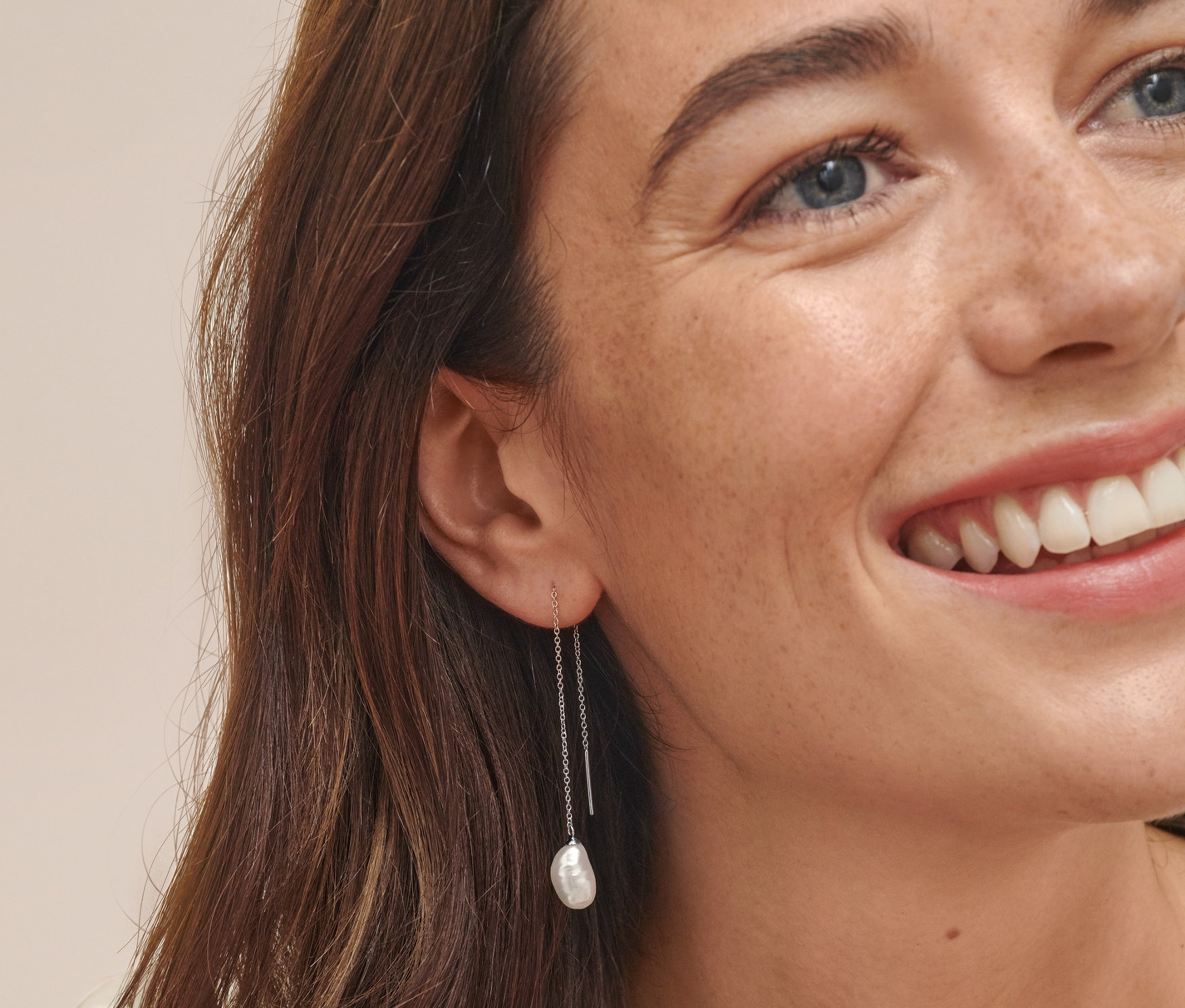 Žena má na sobě náušnice z rhodiovaného stříbra 925/1000 s uměle pěstovanými sladkovodními perlami.