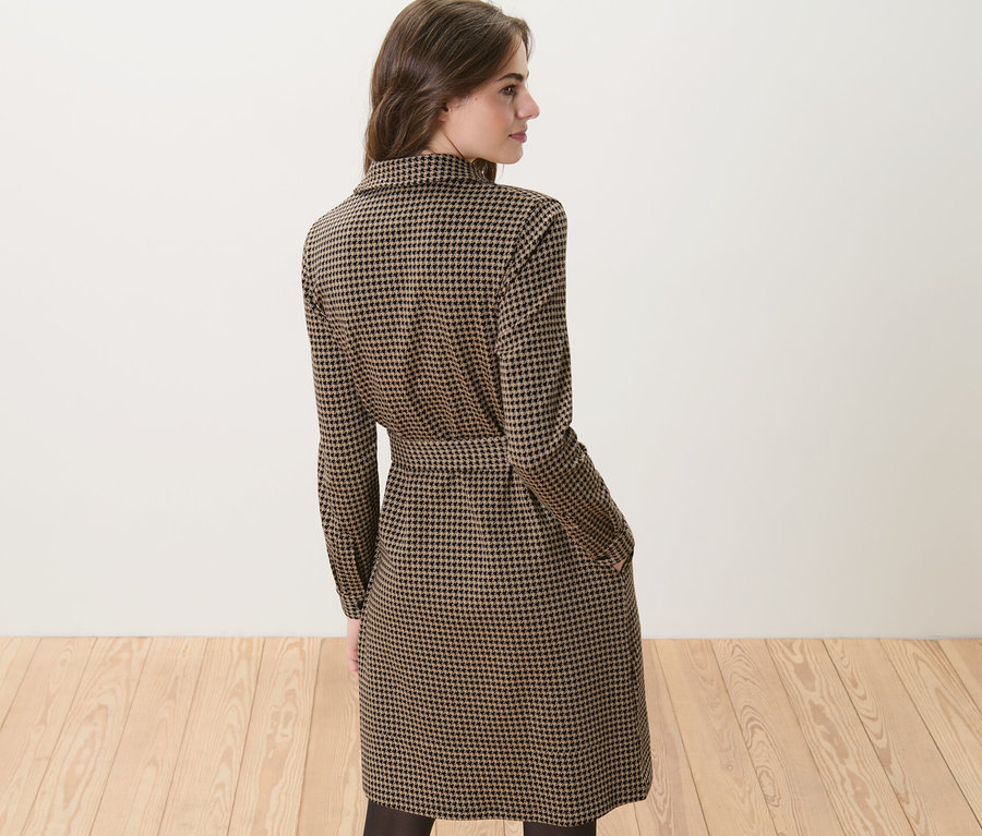 Žena má na sobě teplákové šaty se žakárovým vzorem.