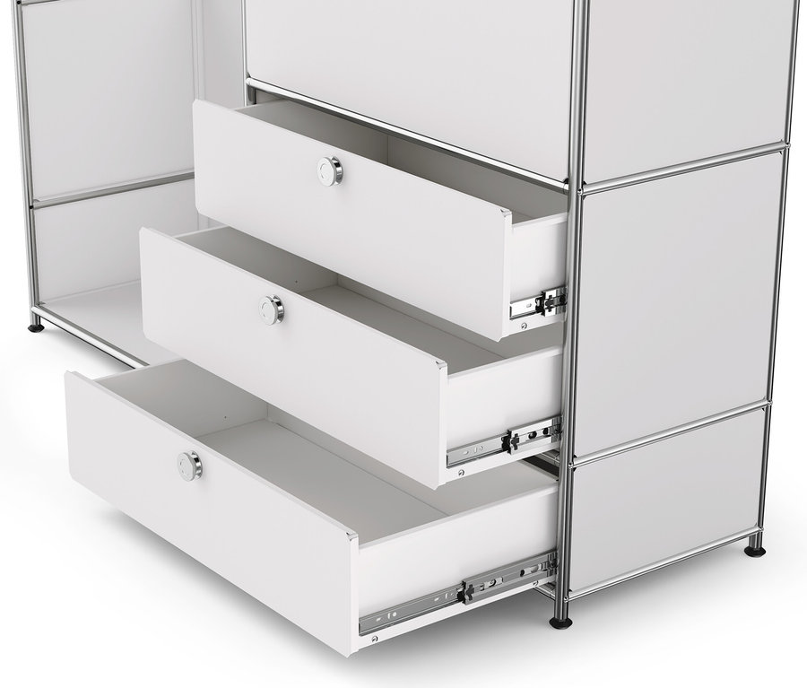 Detail bílé kovové skříně »CN3« s dřevěnou deskou, 1 šatní tyčí, 1 výklopnými dvířky a 3 zásuvkami, přičemž 3 zásuvky jsou otevřené.