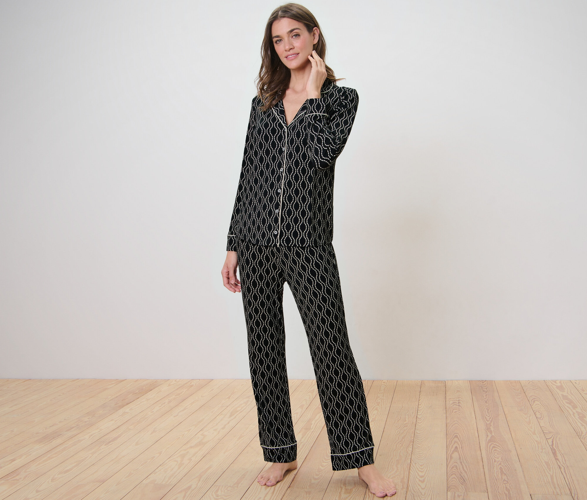 Žena pózuje v pyžamu s celoplošným potiskem.