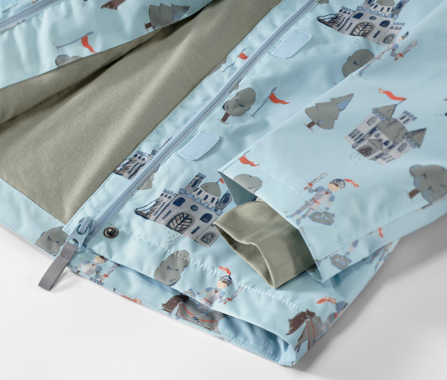 Detail dětské bundy do deště s motivem rytíře.