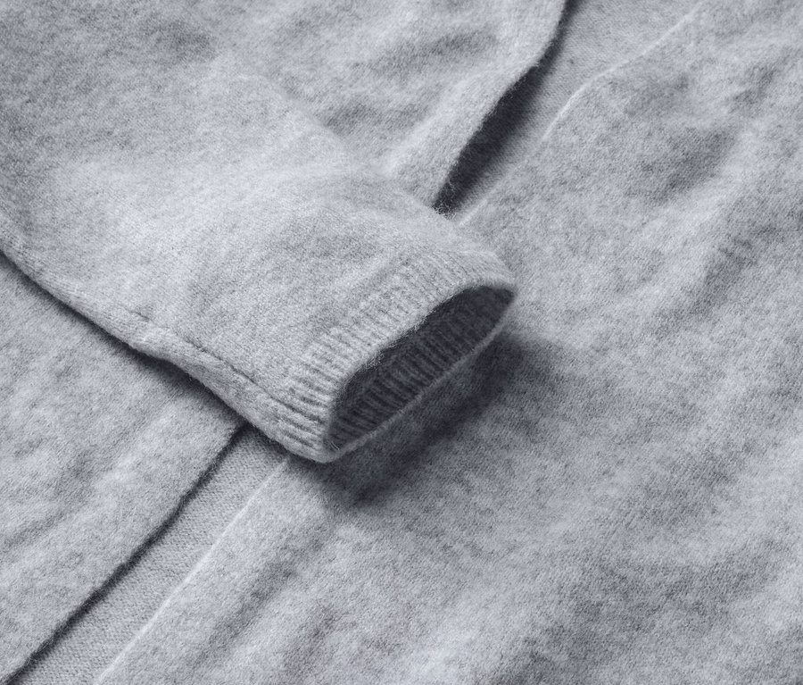 Detail šedého otevřeného kardiganu.