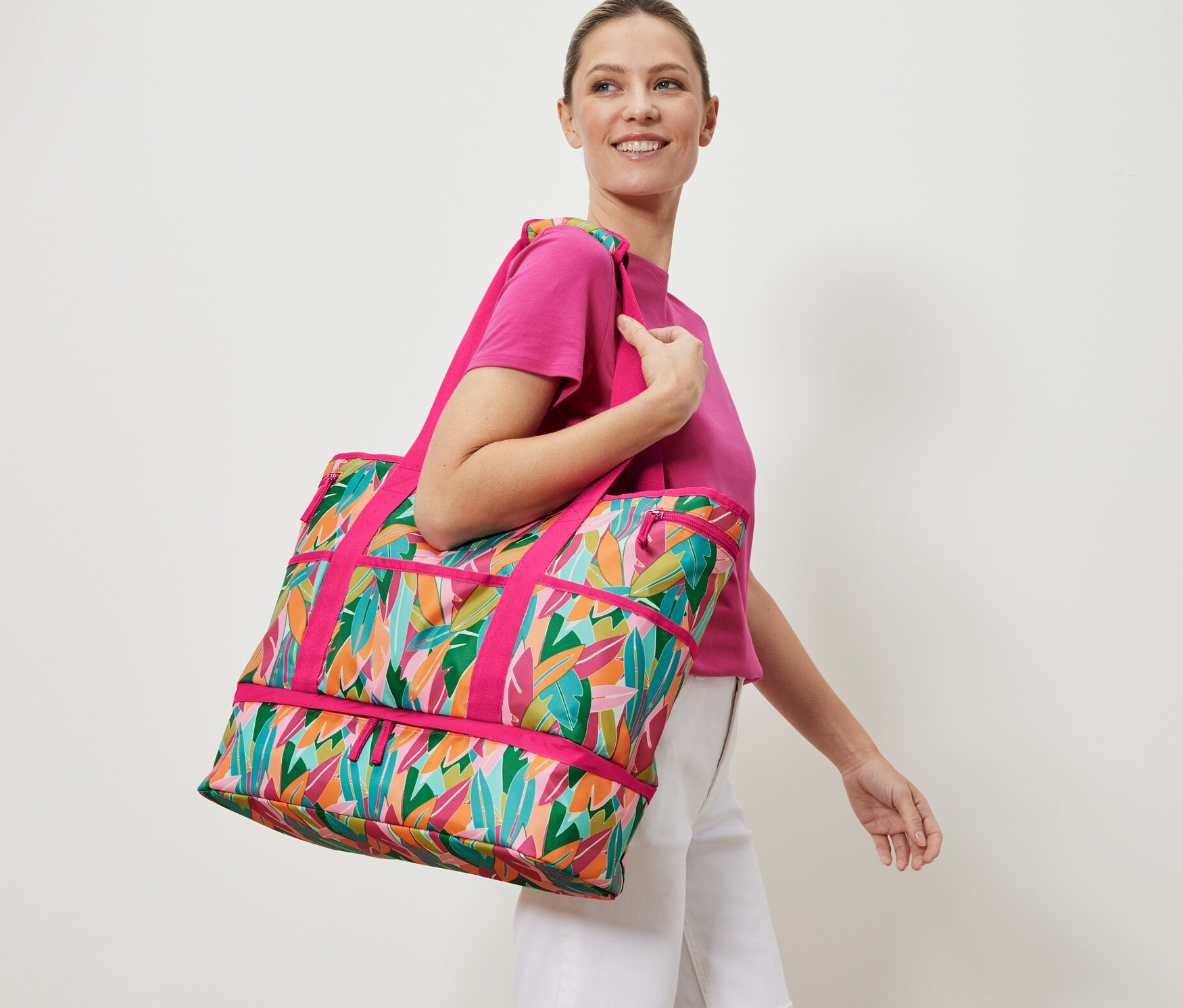 Žena nese plážovou tašku s celoplošným potiskem.