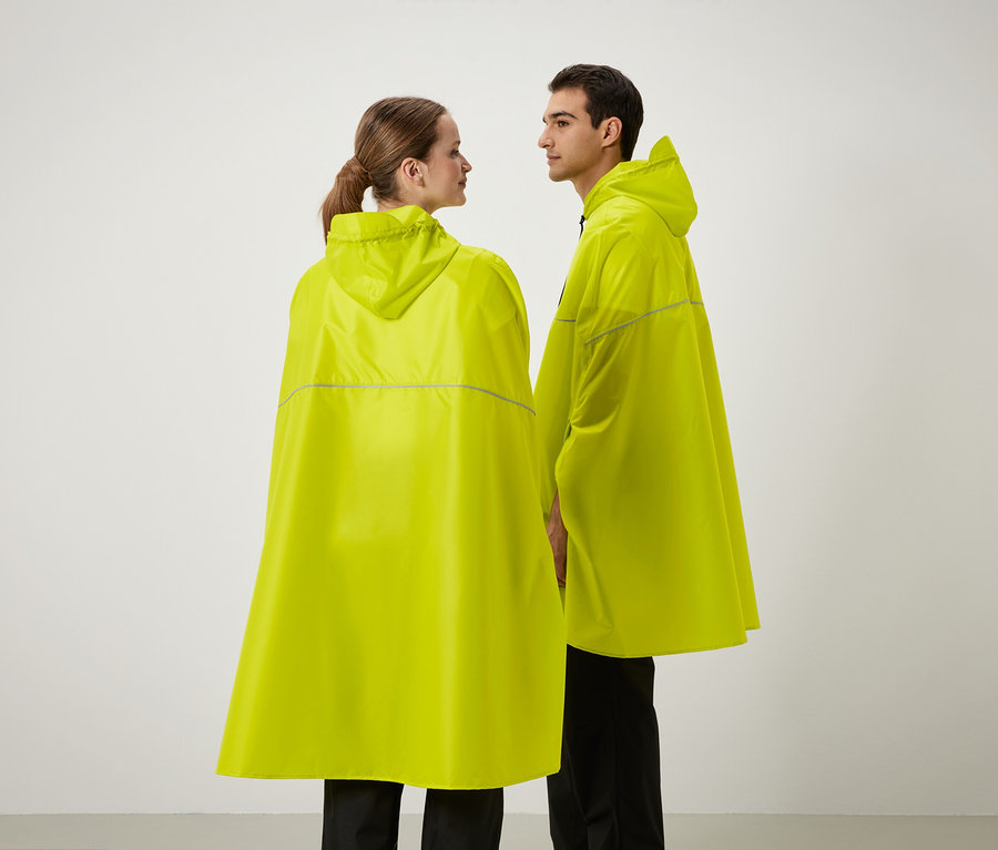 Dva lidé stojí vedle sebe a mají na sobě žluté pláštěnky s kapucí.