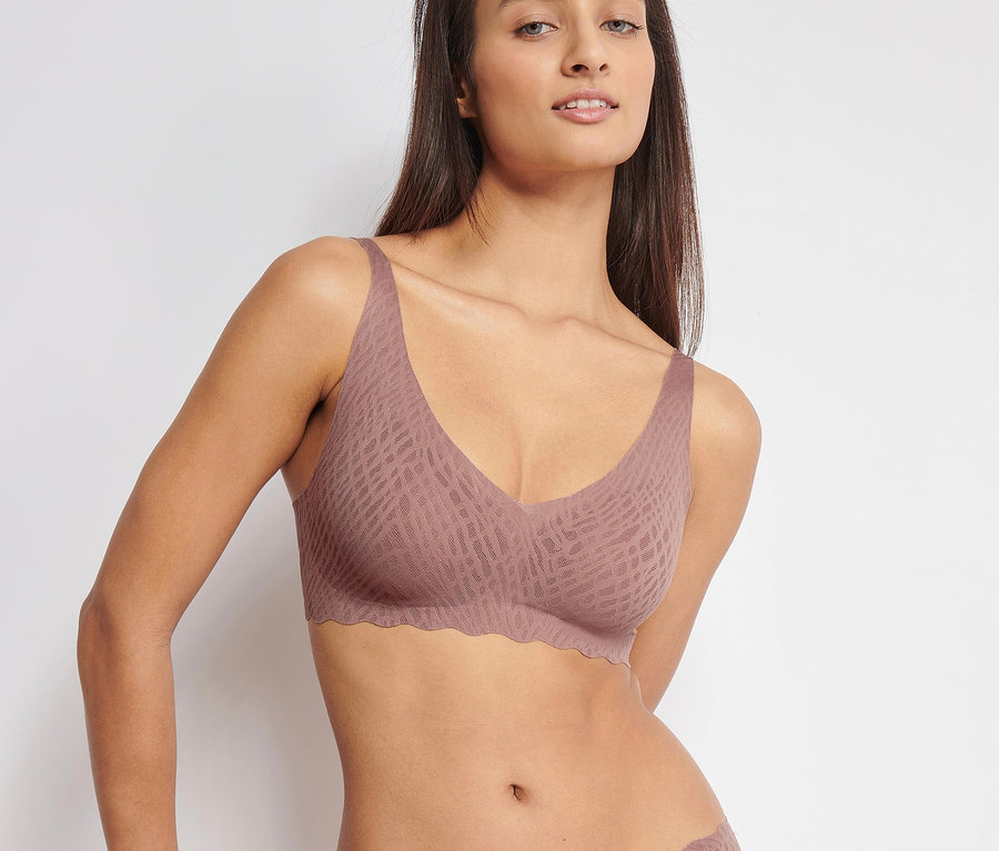Žena má na sobě měkkou podprsenku sloggi ZERO Feel Bliss Soft Bra, cacao a kalhotky.