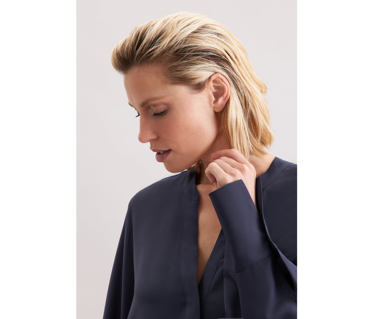 Žena nosí tmavě modrou tuniku z viskózy Seidensticker.