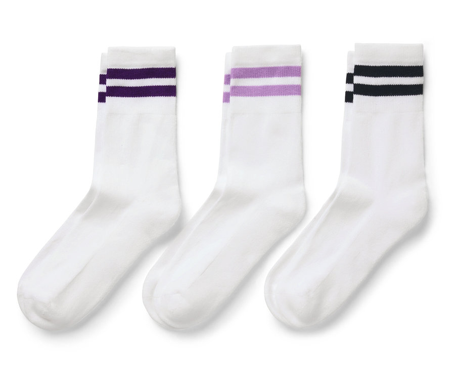 Tři bílé ponožky s barevnými pruhy nahoře.