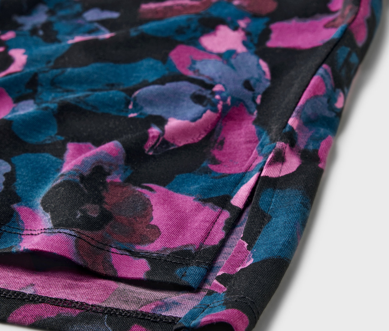 Detail sportovního trička s květinovým vzorem.