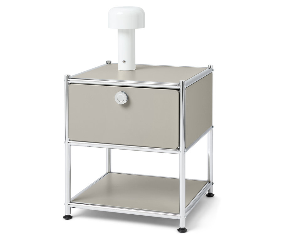 Noční stolek se zásuvkou a bílou lampou nahoře.